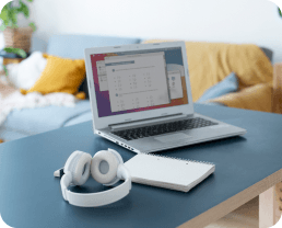 محطة عمل رقمية تضم حاسوبًا محمولًا ومراجع مطبوعة